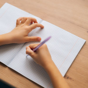 Hands writing on a notebook